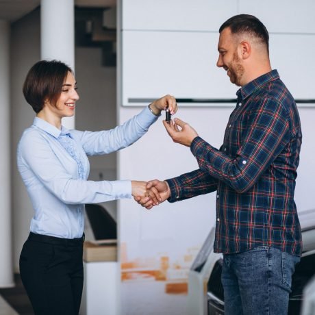 Handsome man buying a car in a car showroom