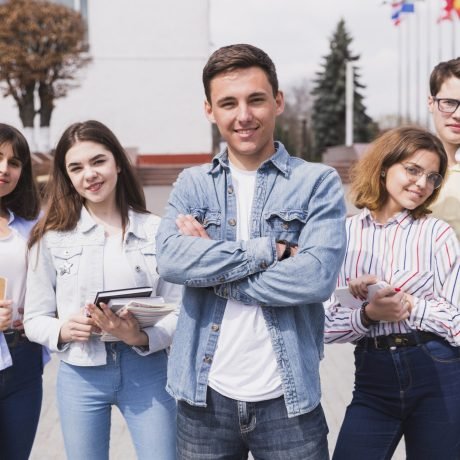 homme-entoure-d-etudiants-intelligents-avec-des-livres-en-regardant-la-camera